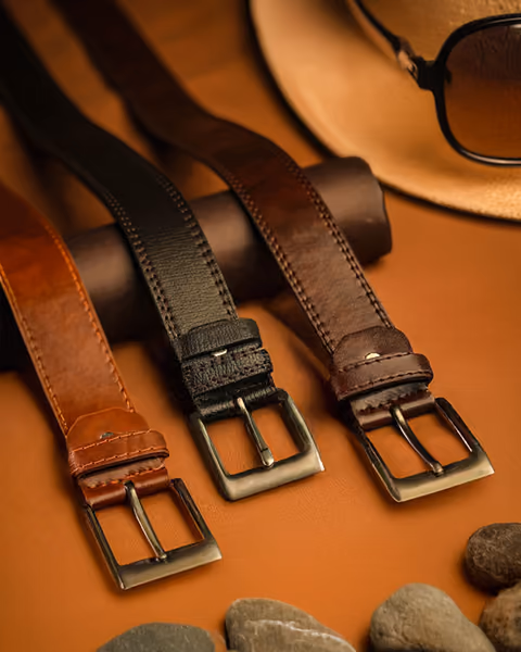 Leather belts laid out on a warm background