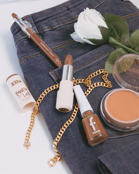 Makeup, denim and a white rose styled together